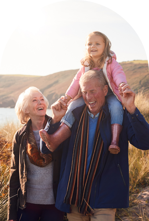 grandmother and grandfather with their granddaughter on his shoulders